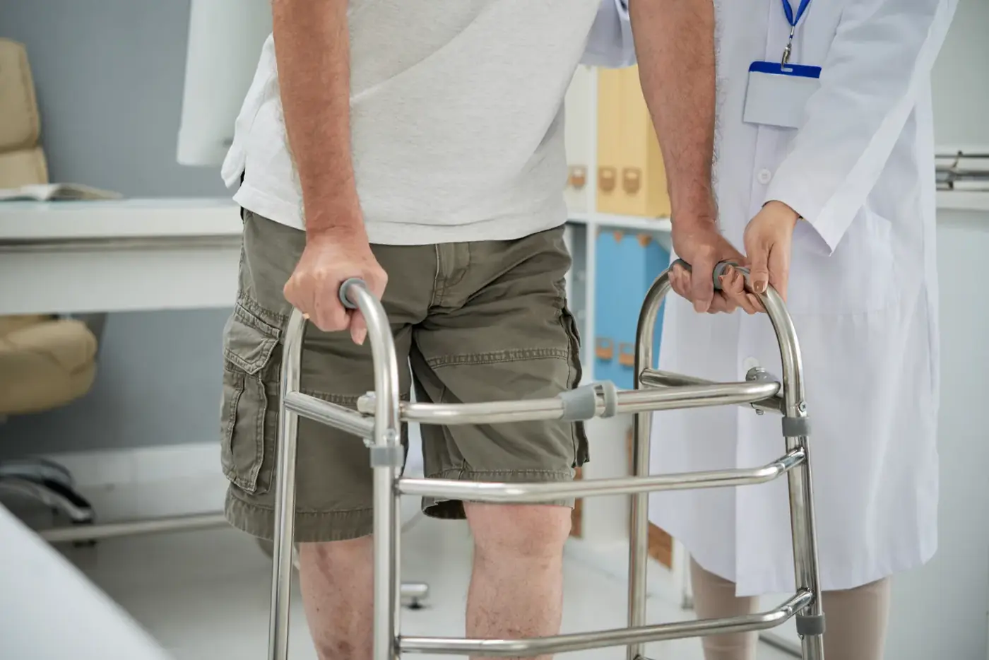 Un paziente muove i primi passi con il deambulatore accompagnato dal medico