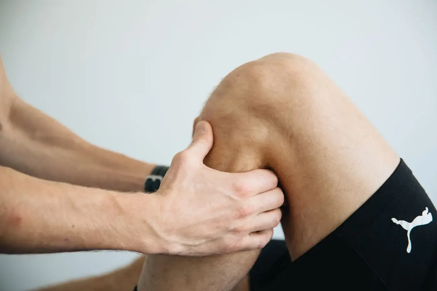 Esame manuale del ginocchio: le mani del medico valutano l'articolazione