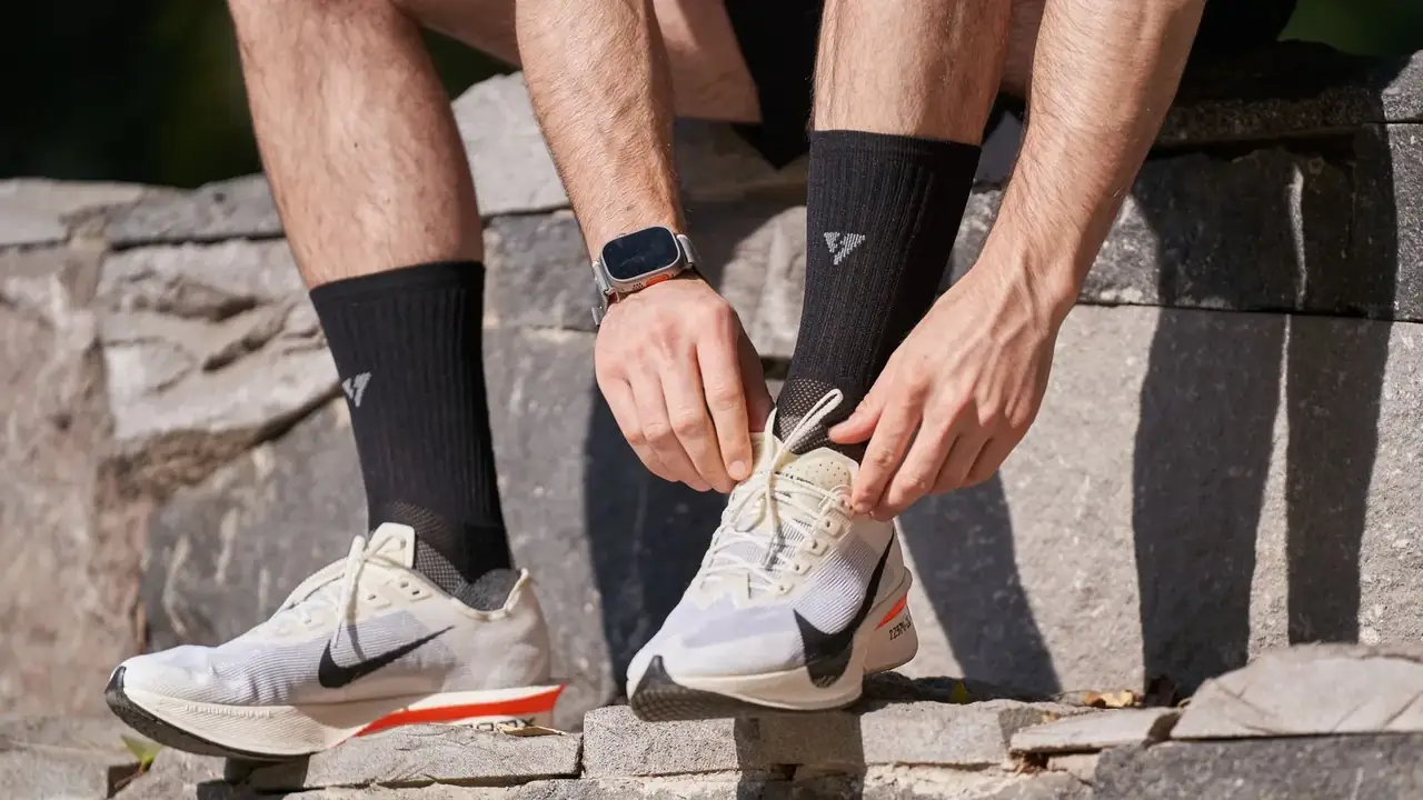 Un uomo allaccia le scarpe da corsa prima di allenarsi